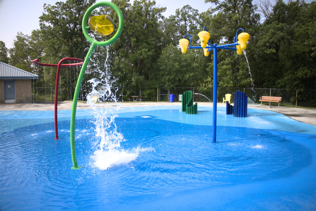 A photo of a waterplay park with several water features actively spraying water. 